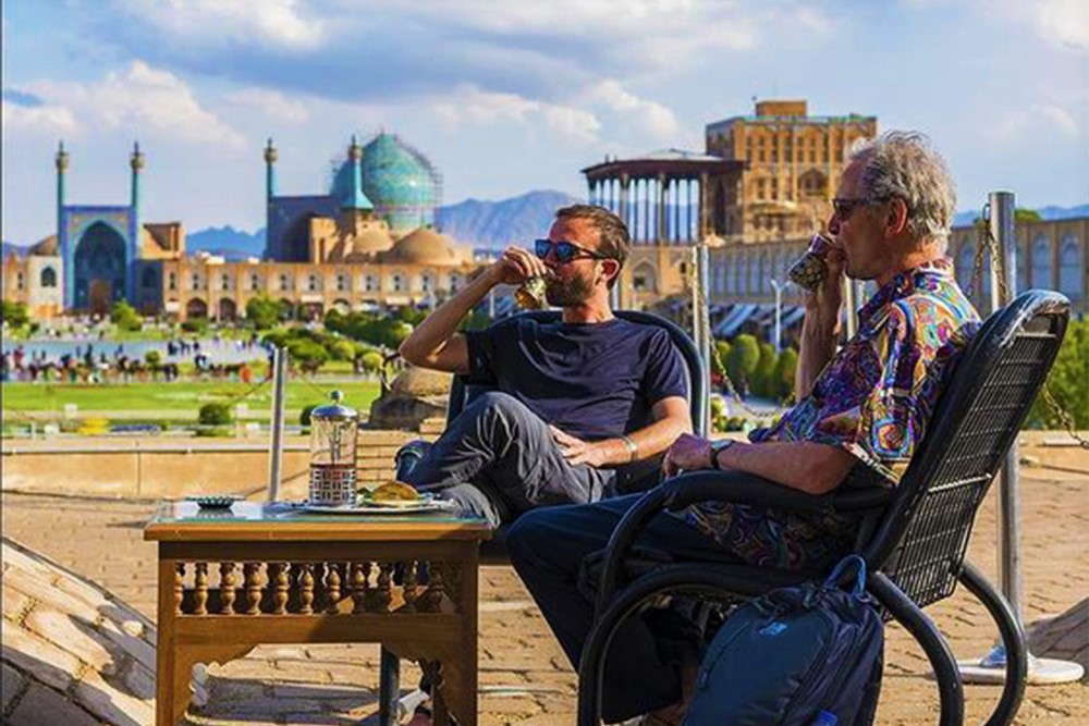 Travel to Iran: tourists enjoy their herbal drink in Isfahan